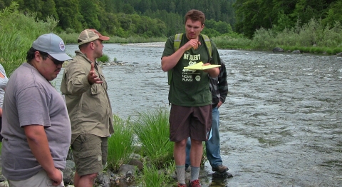 a group of people standing next to a river