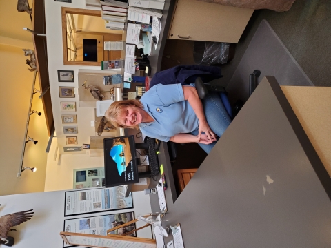 A volunteer staffs the front desk at the Visitor Center.