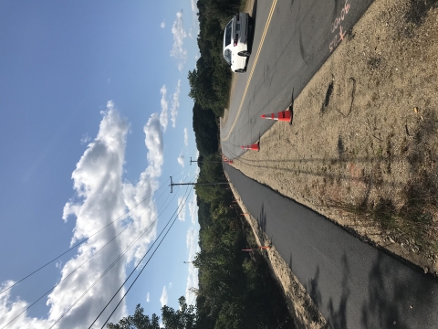 A newly built pedestrian trail parallels a two-lane highway as it skirts the marsh