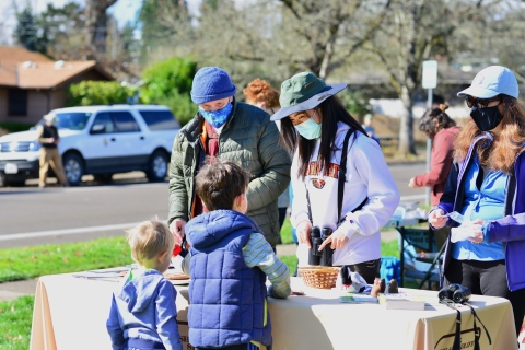 Three volunteers teaching two young boys about birds at the Winter Wildlife Field Day Festival