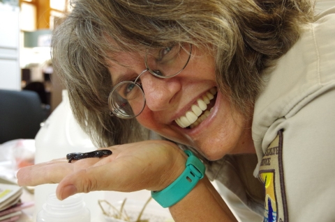 face of woman with small salamander in hand