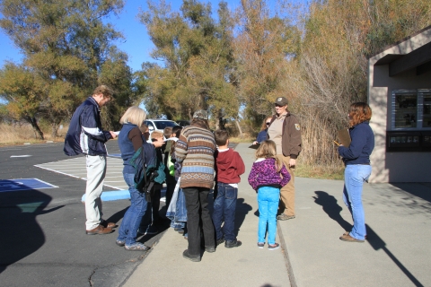 group of kids and adults talking to ranger