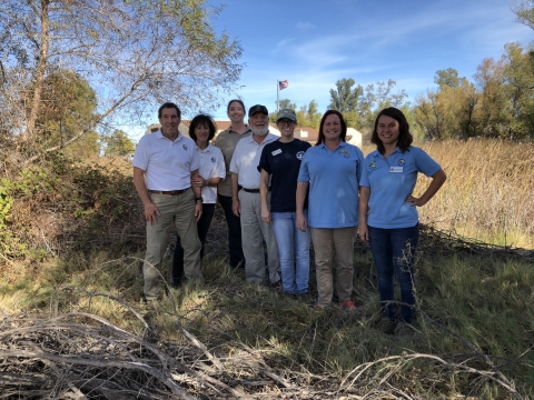 7 volunteers facing camera with sac visitor center in background