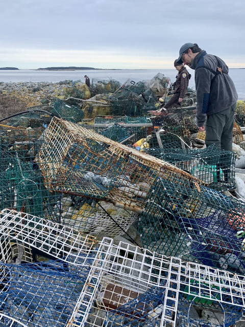 three people search through a mountain of marine debris