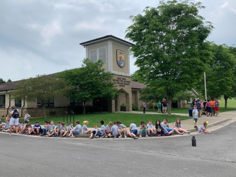 group of students sitting on a curb 