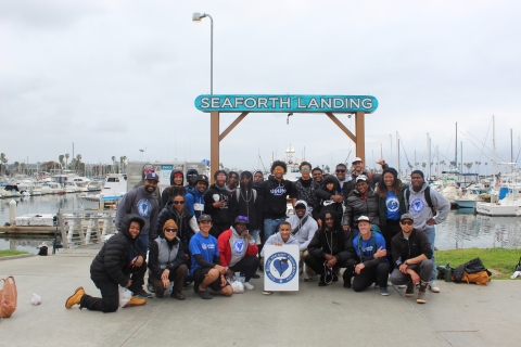 Large group of individuals standing on a fishing dock with the words "Seaforth Landing" behind.