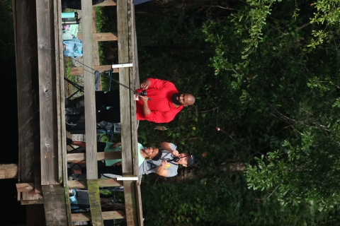 A smiling man, woman and young boy fishing from a pier 