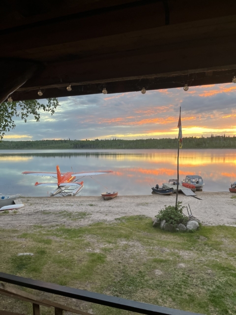 airplane sits on the beach at a lake