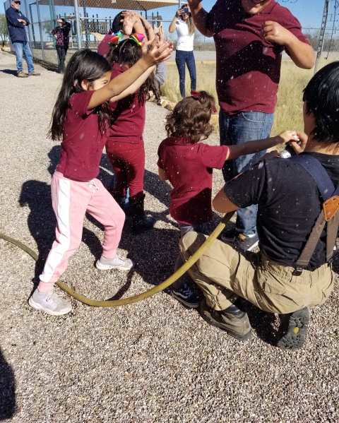 5 kids around squatting adult