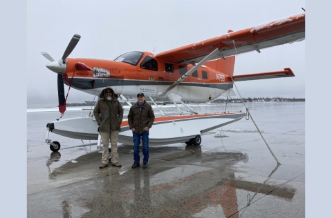 2 people standing in front of an airplane