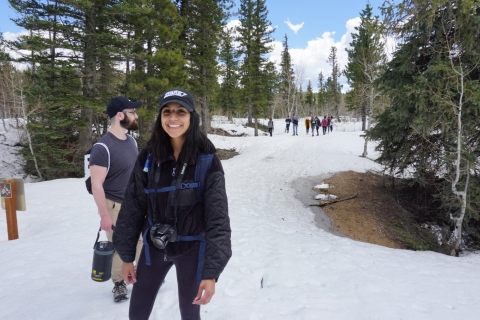 Lory leads a hike on a snowy trail featuring a group of people behind her and a guy next to her