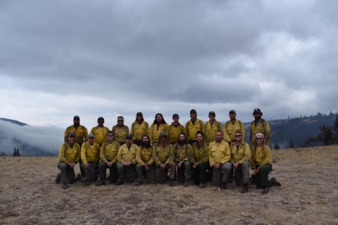 2 rows of firefighters pose for photo outside