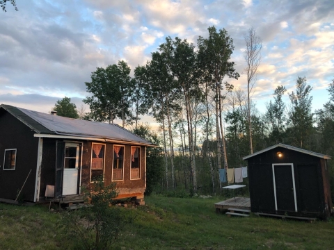 a cabin and outhouse in the woods