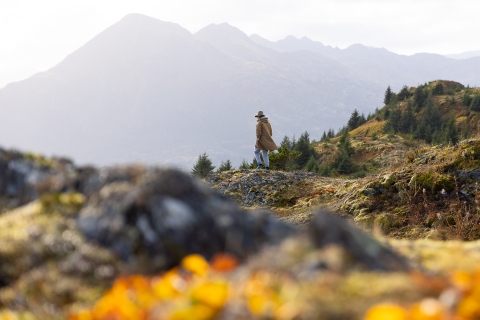 a woman stands on a rocky mountain top