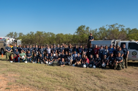 Large group poses for photo outdoors