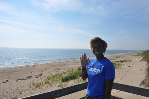 Image of intern waving at beach