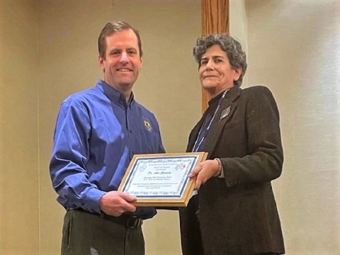 Two people smiling and holding an award