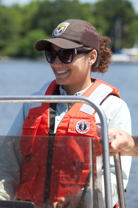 Up-close photo of FWS employee driving boat