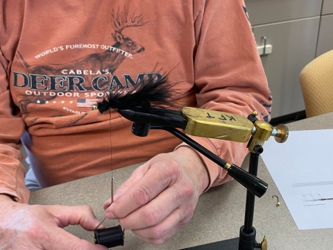 Black fly in a fly-tying vice