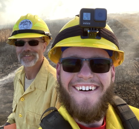 2 men in hardhats smile at camera