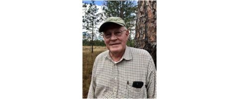 Close-up Charley Tarver standing in front of longleaf pine tree.