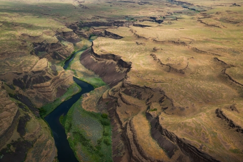 A river winds through a heavily channeled canyon