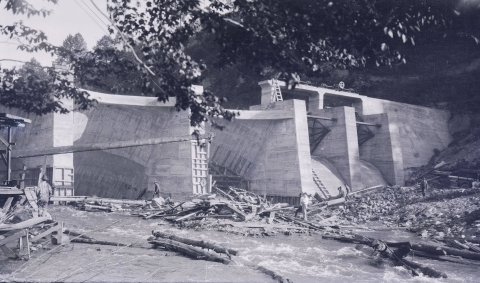 Partially constructed dam with the stream passing by in the foreground.