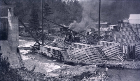 Dam under construction with river flowing by construction area