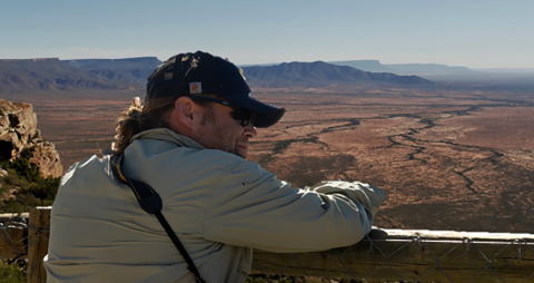 Man standing against railing and look out over the landscape