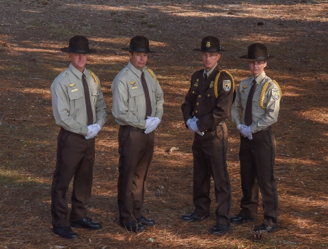 Four uniformed employees stand together.