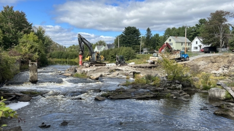 Construction equipment working on the side of a flowing river