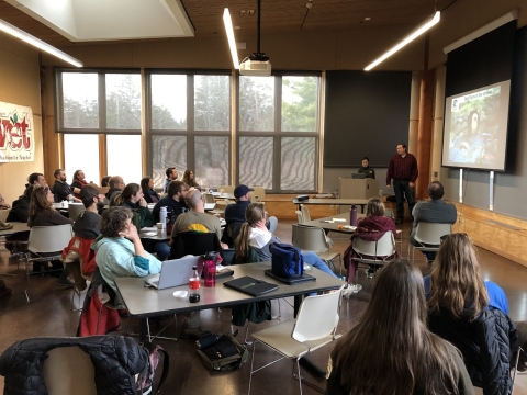 Students sitting at tables watching a presentation