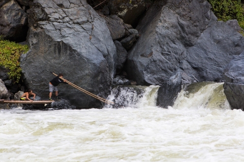 two men use dip nets to fish at waterfall