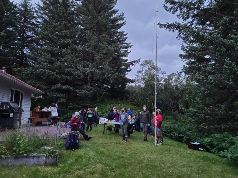 People stand around a high fine vertical net