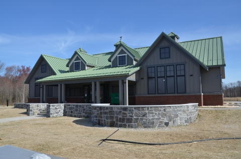 Tan building with green roof and what appear to be solid, opaque, witdows