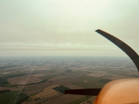 view from an airplane of a smoke filled sky 