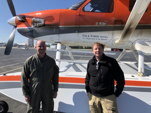 two people standing in front of an aircraft