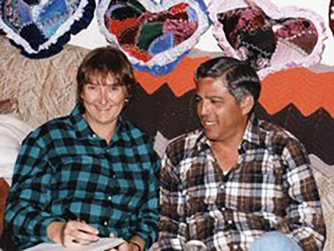 John Cantu with his wife, Linda Carlson sitting on a couch, both smiling.