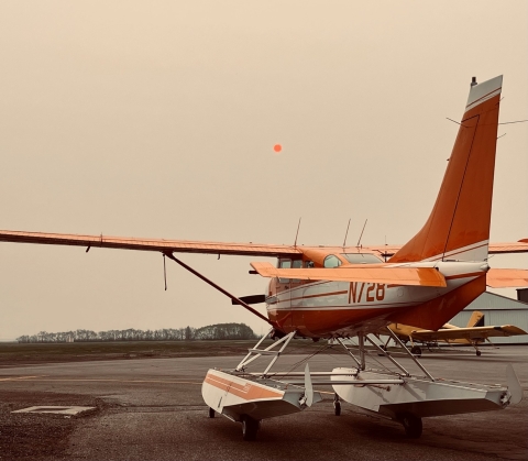 smoke filled sky with an airplane waiting to take off