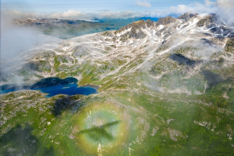 aerial photo of a floatplane shadow over a mountain