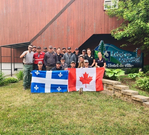 A group shot of 20 people holding flags