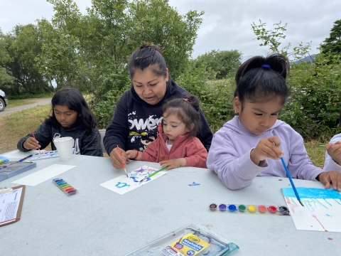 4 people sitting at an outdoor table watercolor painting