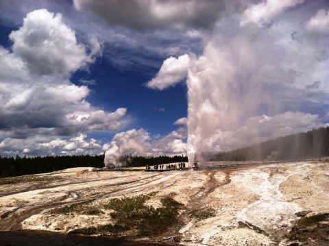 Steam rises in the air from two vents on a rocky landscape.