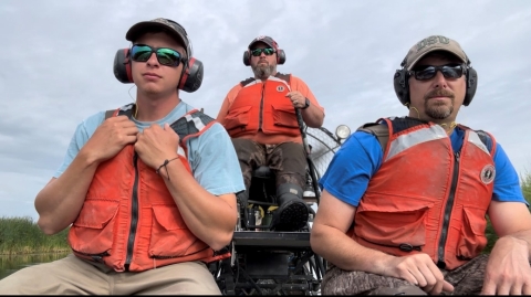 three people riding in a boat