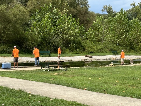 People fishing at a stream