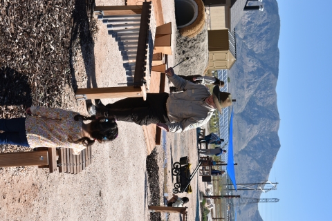 Staff and youth playing with xylophones in the music area with a mountain background