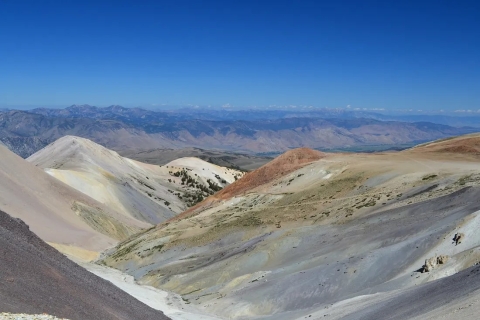 View looking down from the mountains. Dry desert mountains off in the distance.