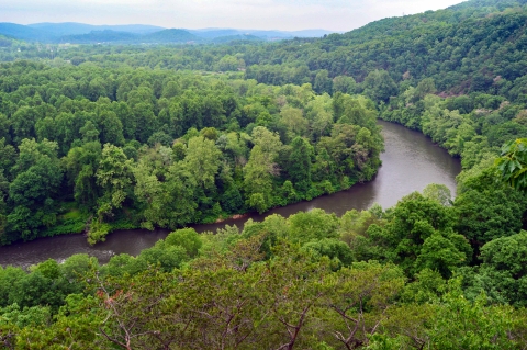 A high view of verdant hills with a river curving through