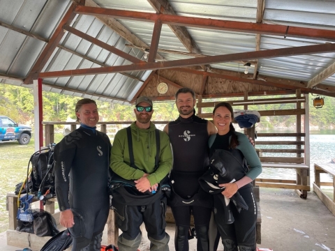 Dive team members pose together under picnic shelter