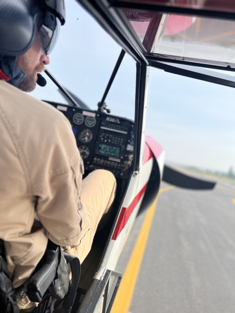 Close Up of Federal Wildlife Officer/Pilot taxis at an airport with the entry window/door open.